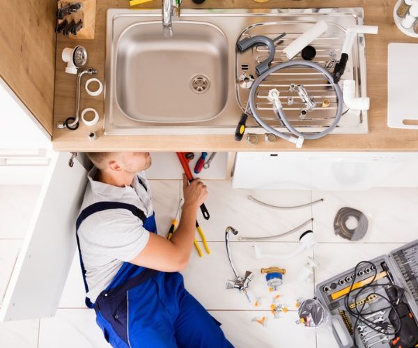 Professional plumber fixing pipes